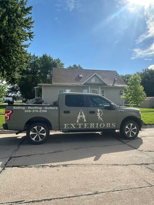 The AR Exteriors truck parked in front of a finished house